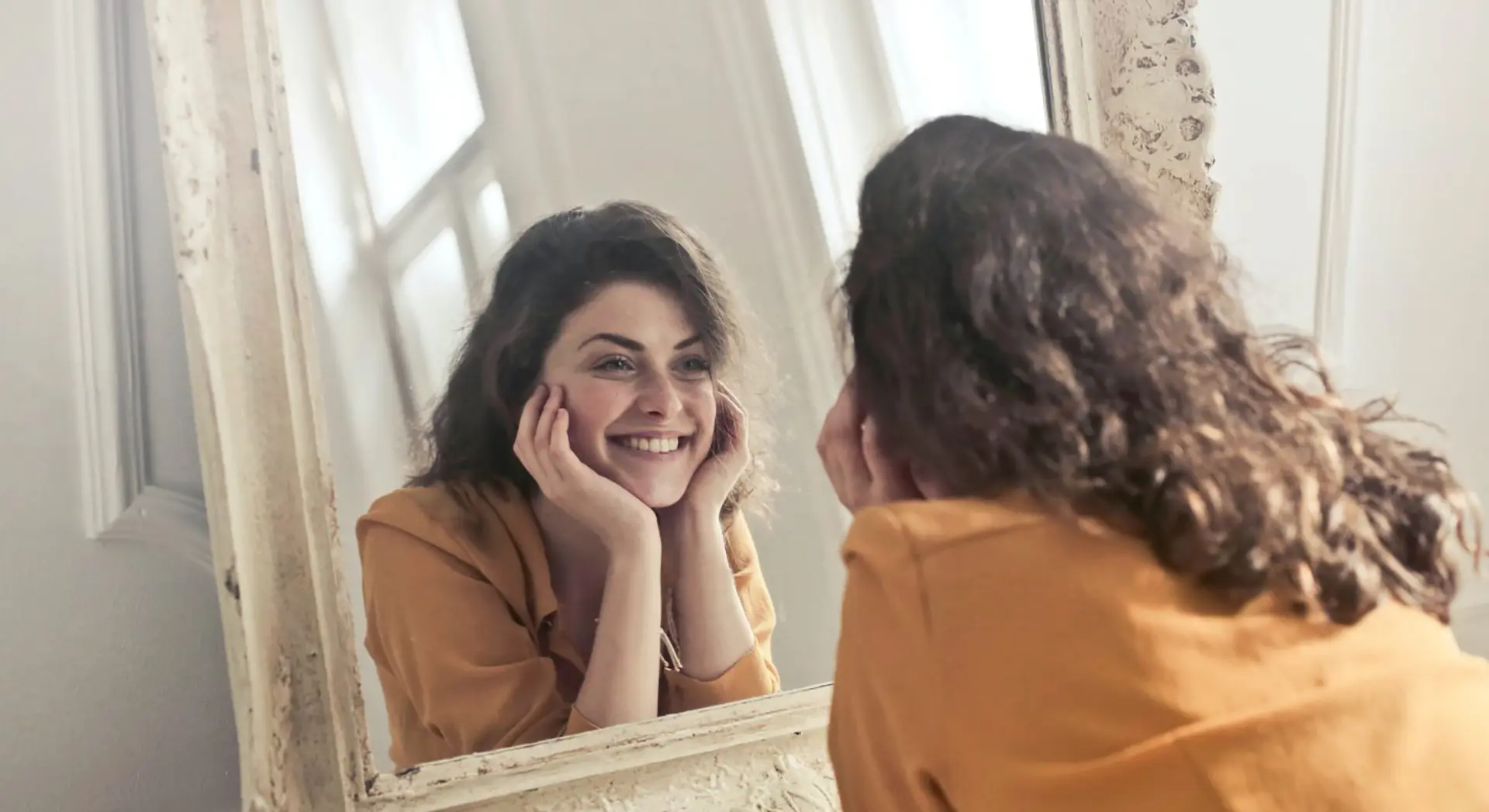 Frau lächelnd vorm Spiegel