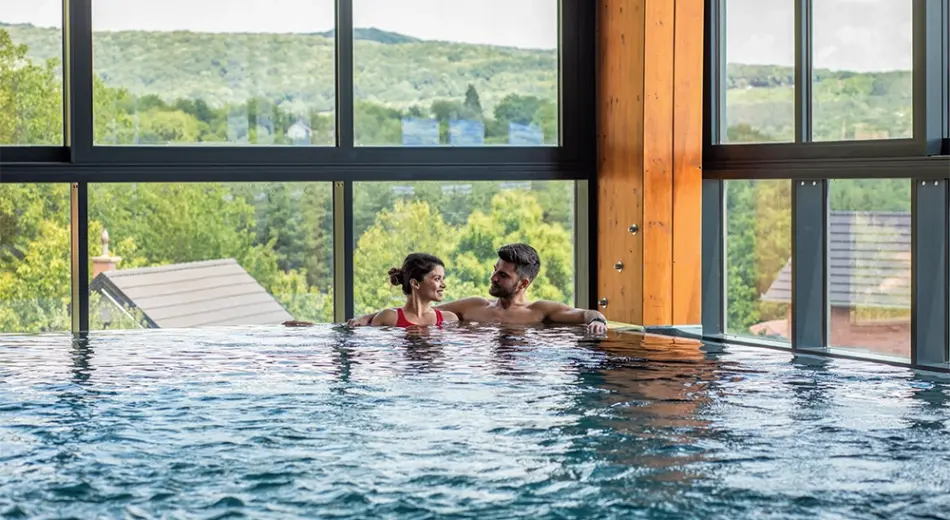 Ein Paar entspannt im Pool eines der schönsten Wellnesshotels.