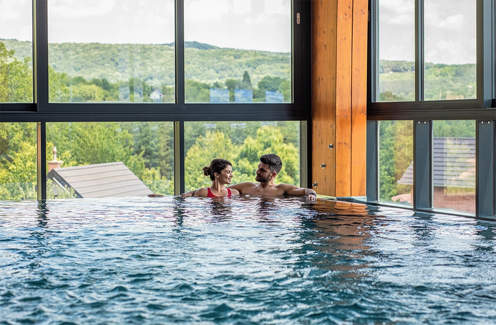 Ein Paar entspannt im Pool eines der schönsten Wellnesshotels.