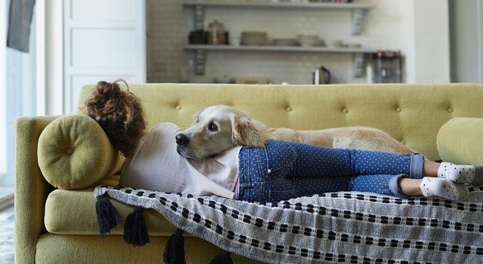 Frau auf der Couch rastend mit ihrem Hund