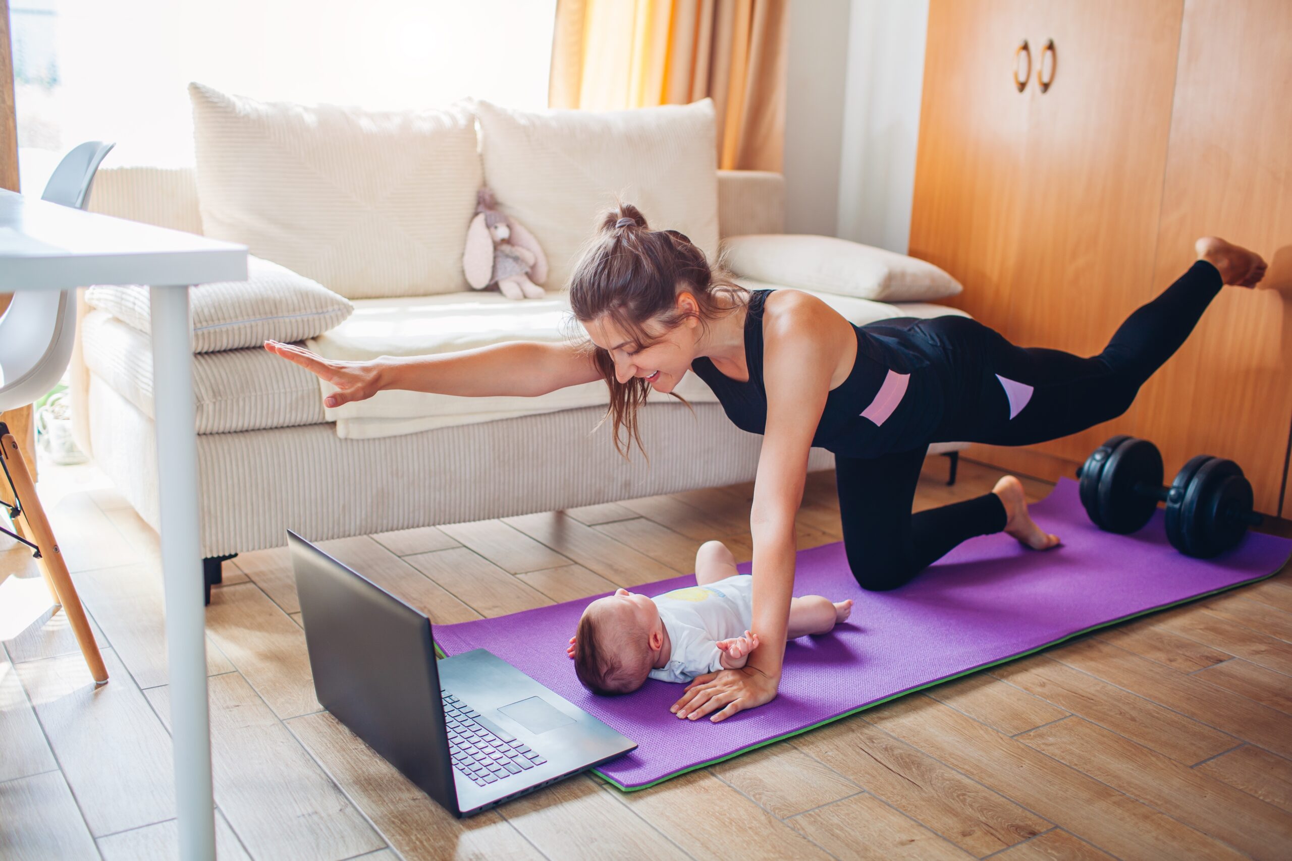 Frau die zu Hause mit Kind Sport macht