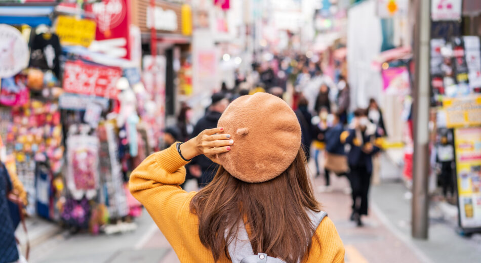 Eine junge Reisende spaziert auf der Takeshita-Straße in Harajuku, dem Zentrum der Teenager-Mode- und Cosplay-Kultur in Tokio.