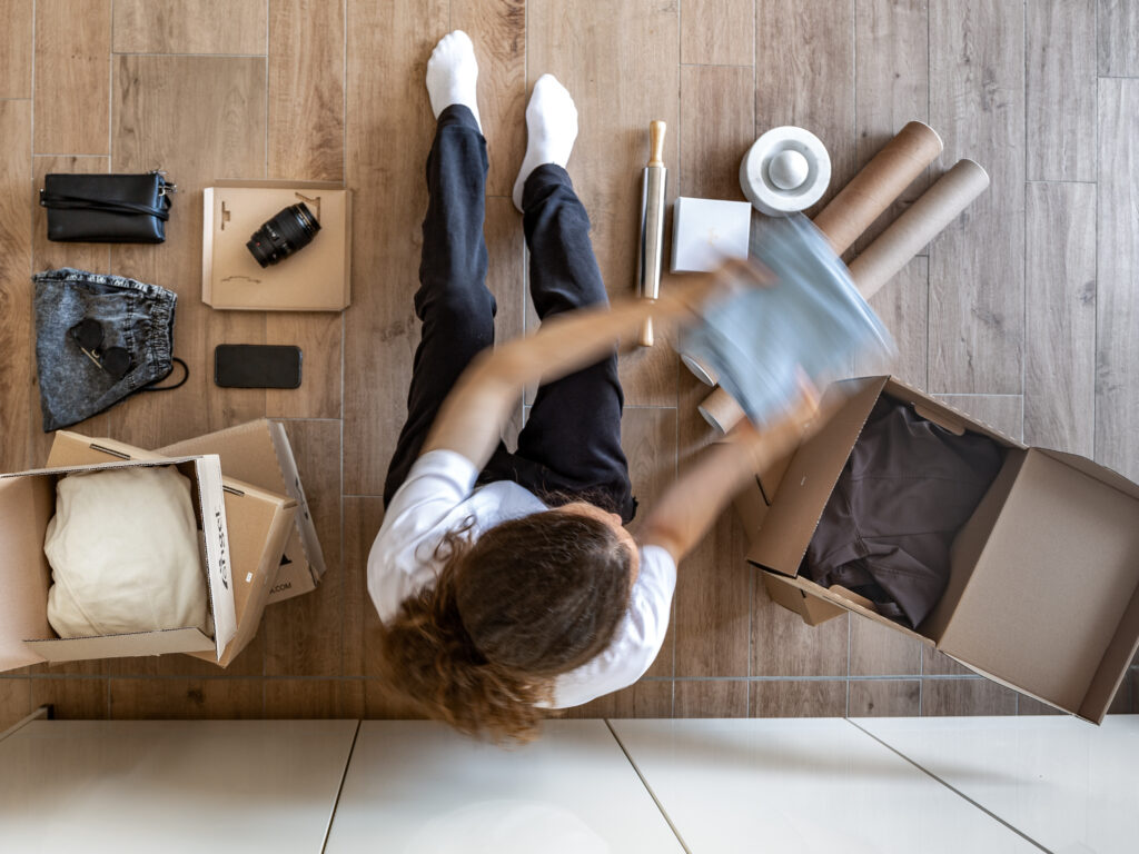 Person die ihre Kleidung aussortiert und organisiert.