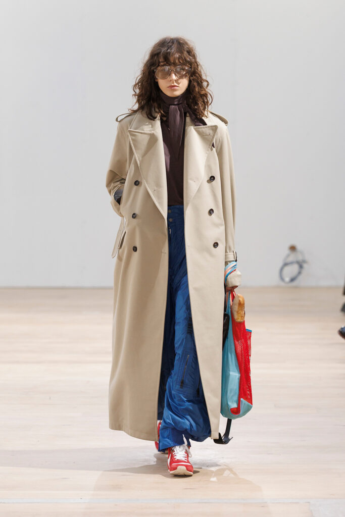 Frau die beigen Trenchcoat trägt, Laufstegbild