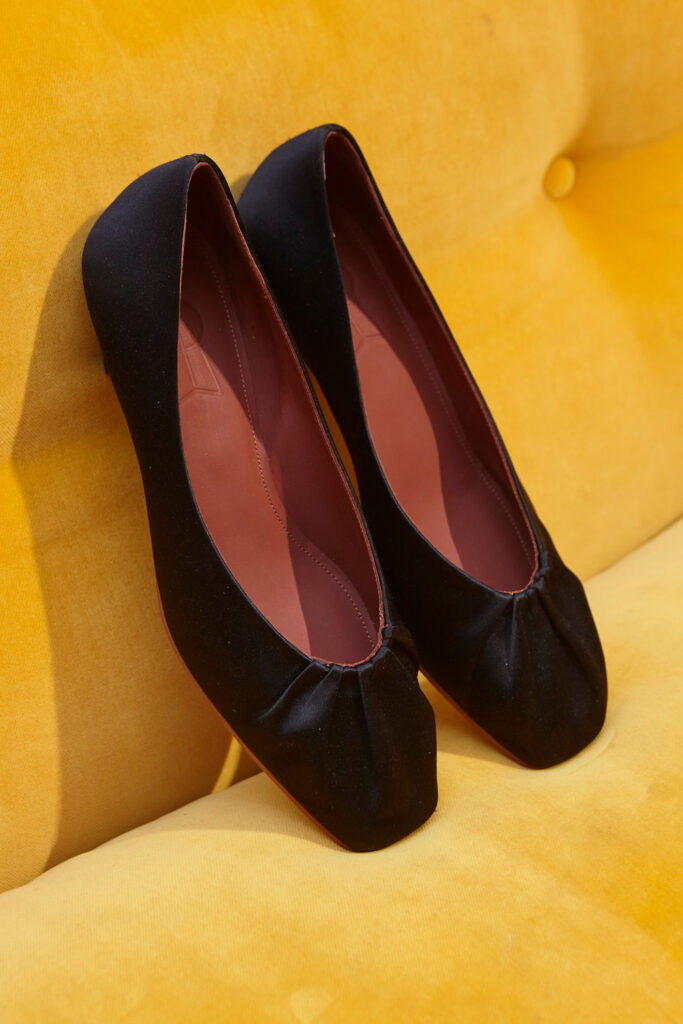 schwarze Ballerinas auf gelbem Sofa