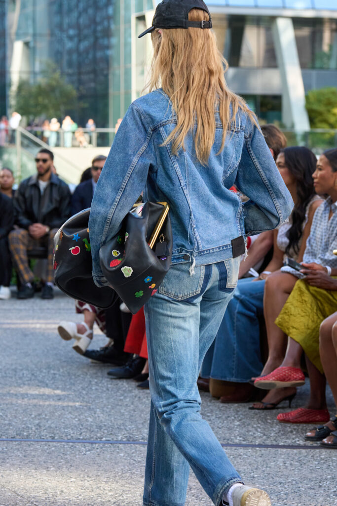 Frau von hinten die Jeansjacke und Jeans trägt