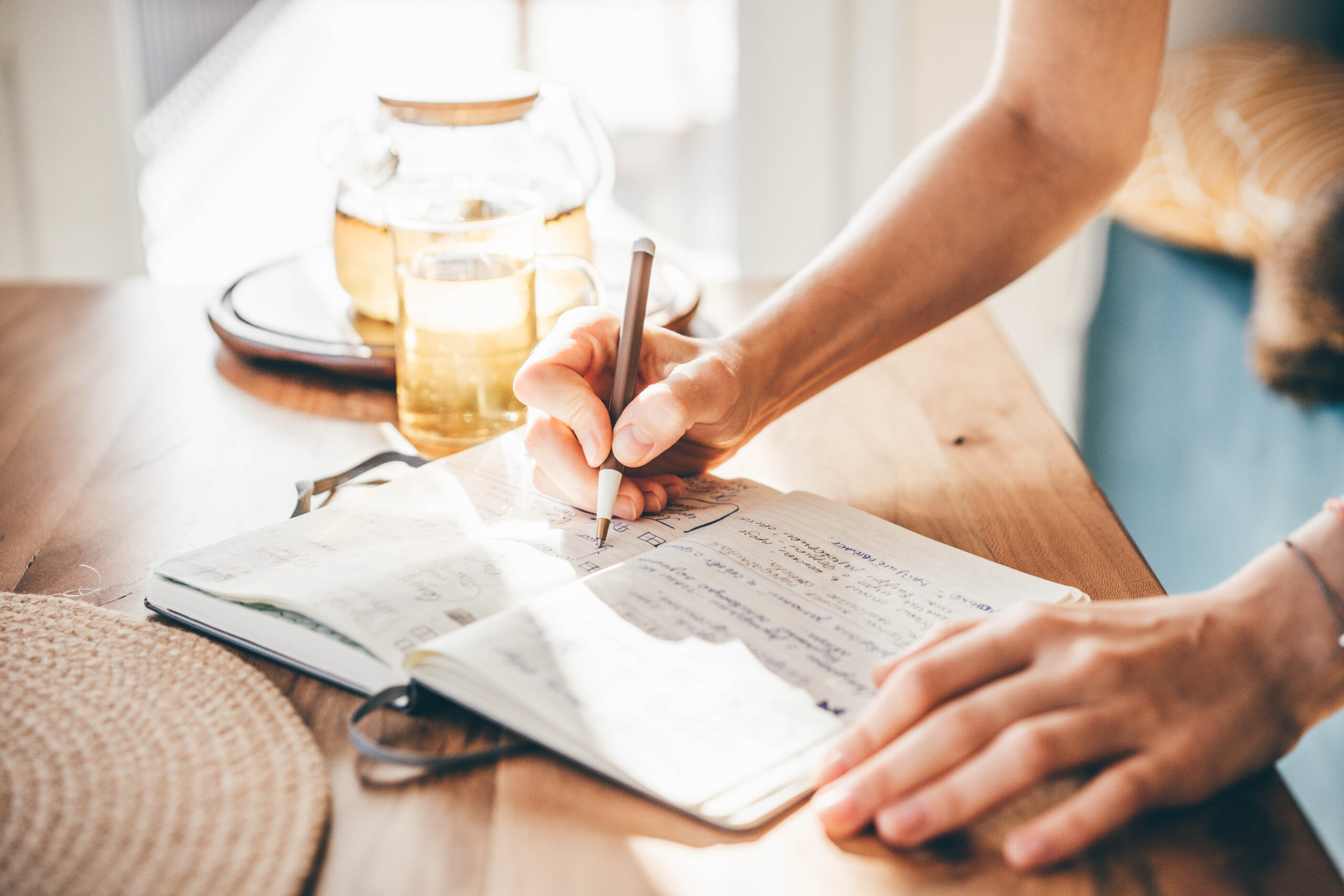 Eine Frau schreibt in ein Notizbuch.