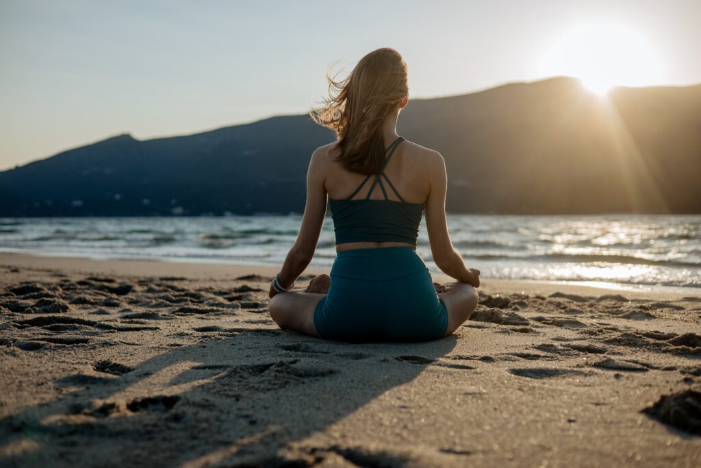 Frau die meditiert, am Strand