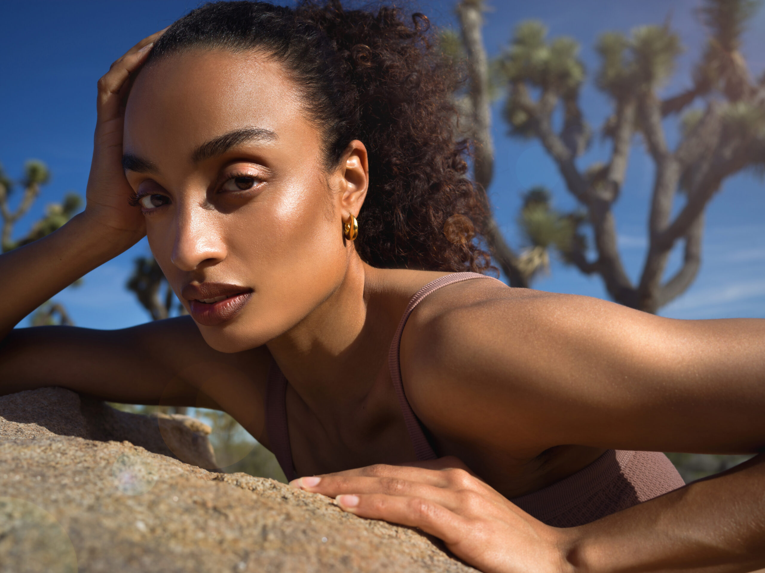 maxima Sonnenschutz Editorial Shooting, Model auf einem Stein liegend, von der Sonne angestrahlt