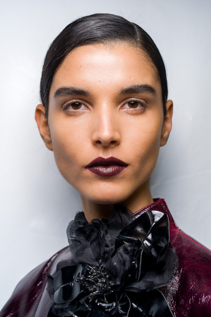 Model Close up mit dunklen, kurzen sleek Haaren und brombeerfarbenem Lippenstift, Kollektion Elie Saab