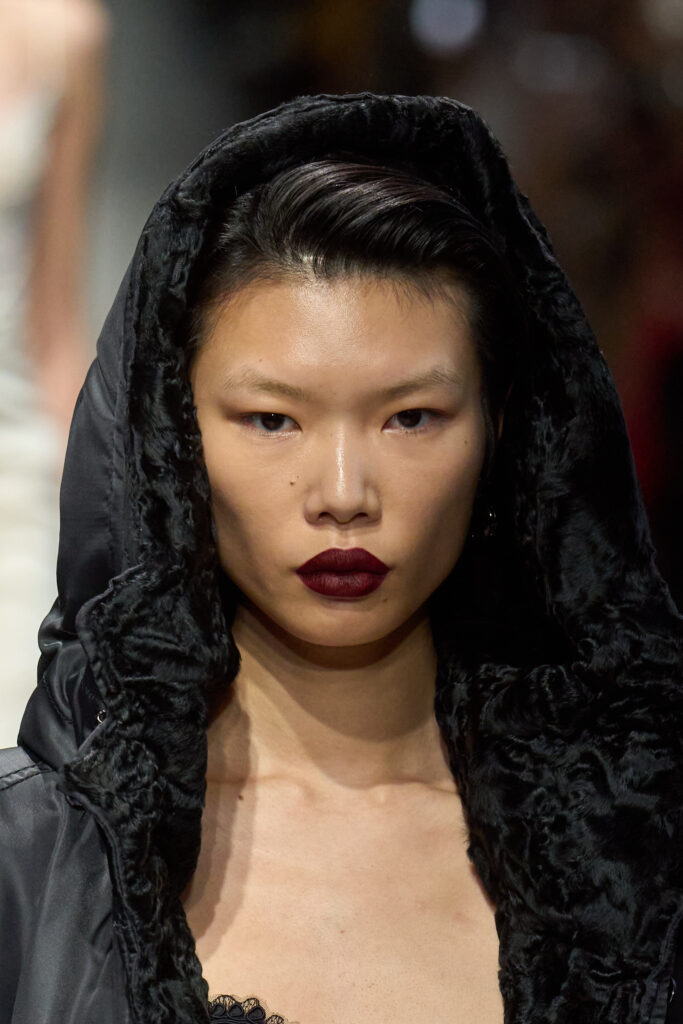 Model mit dunkler Kaputze am Haupt, Gothic Style, und dunkelroten Lippen, Kollektion Scervino