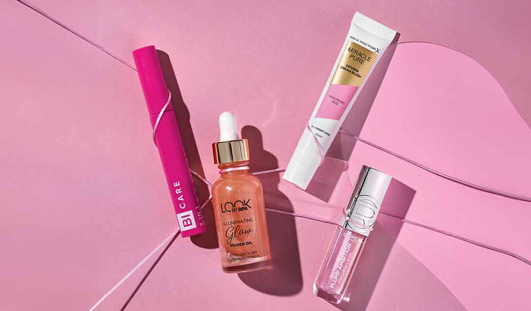 Freisteller diverser Make-Up Produkte auf pinkem Hintergrund