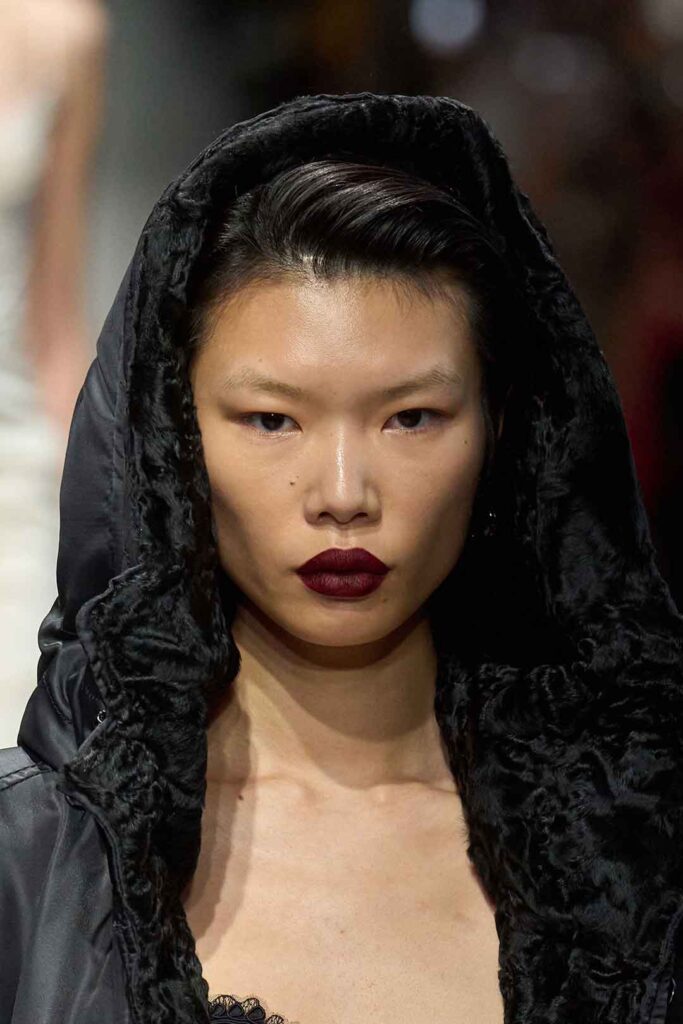 Model mit dunkler Kaputze am Haupt, Gothic Style, und dunkelroten Lippen, Kollektion Scervino